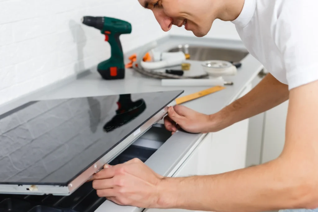 A man engaged in a home improvement project, installing a kitchen appliance.